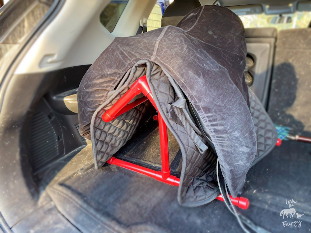 A red homemade saddle rack with a saddle on it