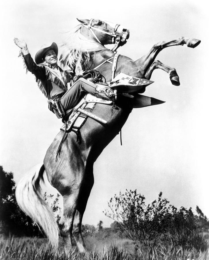 A man on a rearing horse smiling