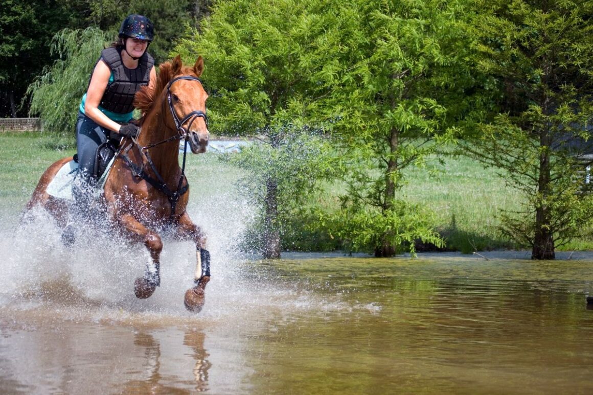 Woman riding a running horse in the water